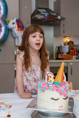 Baby Girl Blowing Candles Of A Birthday Cake