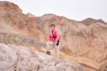Fototapeta premium A family with a teenage girl is hiking Dante’s View trail in Death Valley National Park in California, USA during their road trip from Las Vegas to San Francisco in March 2021 during COVID-19 pandemic