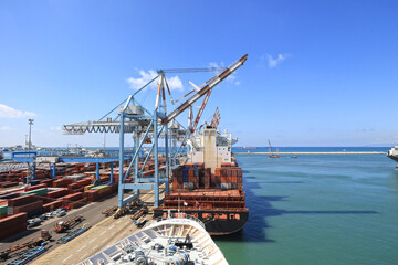 Container handling gantry cranes at a container terminal. Ships at Dock. Haifa, Israel. Blue sky.