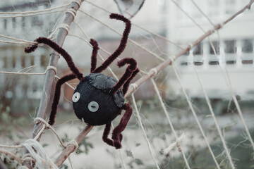 Closeup shot of a black toy spider on a fake spider web