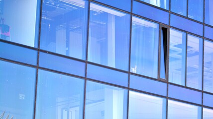 Plakat Mirrored windows of the facade of an office building. Abstract texture of blue glass modern office building. Business background.