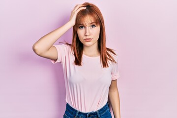 Redhead young woman wearing casual pink t shirt confuse and wonder about question. uncertain with doubt, thinking with hand on head. pensive concept.