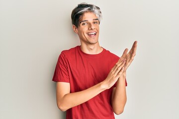 Young hispanic man wearing casual clothes clapping and applauding happy and joyful, smiling proud hands together