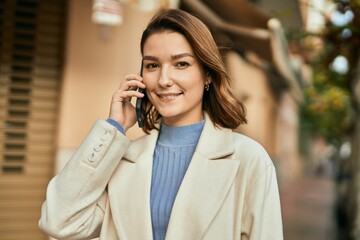 Young hispanic woman smiling happy talking on the smartphone at the city.