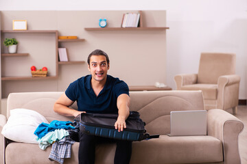 Young man preparing for journey at home