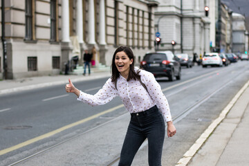 Shallow focus of a young cheerful woman catching a taxi on the street in Bosnia and Herzegovi