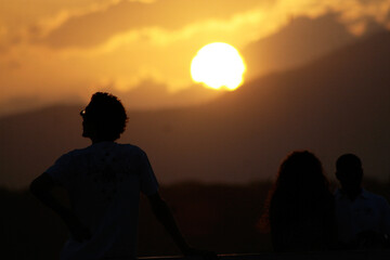 Silueta de personas a contraluz disfrutando de un atardecer en Panamá