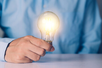Businessman holding light bulb, imagination and intelligence, innovation and inspiration, brain symbol and solution and knowledge, creative idea and success, business and marketing concept.