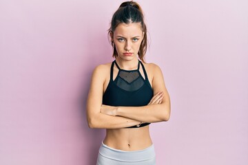 Fototapeta na wymiar Young brunette woman wearing sportswear skeptic and nervous, disapproving expression on face with crossed arms. negative person.