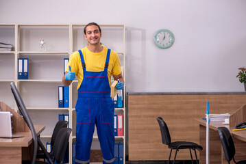 Young male contractor cleaning the office