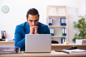 Young male employee and too many work in the office