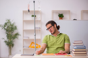 Young sick male teacher student in blood transfusion concept