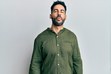 Young hispanic man wearing casual clothes making fish face with lips, crazy and comical gesture. funny expression.