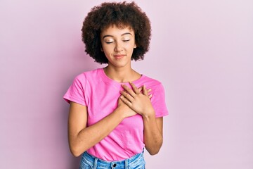 Young hispanic girl wearing casual clothes smiling with hands on chest, eyes closed with grateful gesture on face. health concept.
