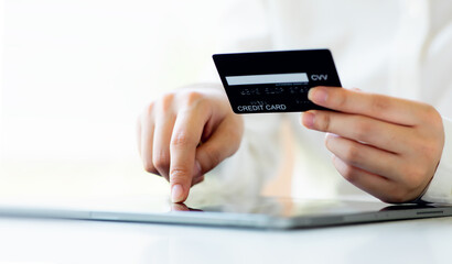 Close up woman hand using credit card and tablet for buying online shopping at home ,payment,buying and online shopping concept.