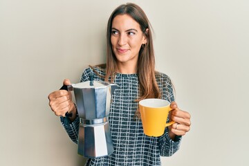 Young beautiful woman drinking italian coffee smiling looking to the side and staring away thinking.