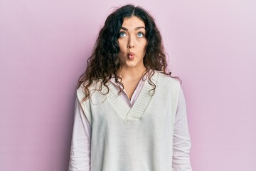 Fototapeta premium Young brunette woman with curly hair wearing casual clothes making fish face with lips, crazy and comical gesture. funny expression.