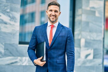 Young caucasian businessman smiling happy standing at the city.