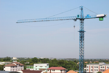 The construction crane on against blue sky.