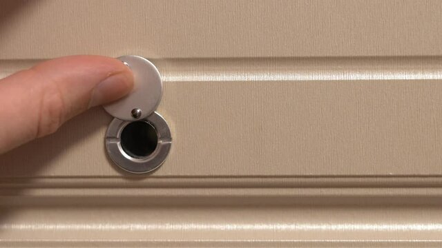 A Finger Opens A Peephole In A Close-up. Unexpected Guests.