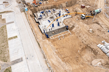 concrete pump working on a foundation of new apartment building. aerial photography with drone
