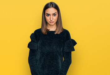 Beautiful brunette woman wearing elegant sweater skeptic and nervous, frowning upset because of...
