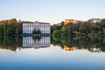 Fototapeta na wymiar Beautiful sunset colors in Leopoldskroner Weiher Lake with Leopoldskron Palace and Hohensalzburg Fortress in the background - Salzburg, Austria 