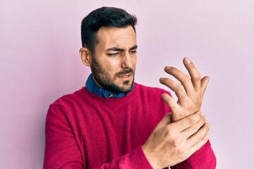 Young hispanic man wearing casual clothes suffering pain on hands and fingers, arthritis inflammation