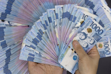 A pile of one thousand Philippines peso banknotes. Cash of Thousand dollar bills, Peso background image.