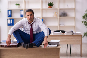 Young male employee doing yoga exercises during break