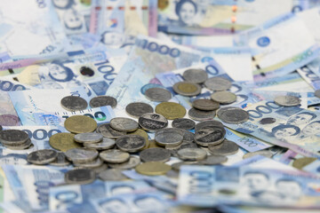 A pile of one thousand Philippines banknotes and coins