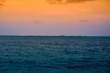 Obraz premium The picture of the bridge stretching out into the sea with the atmosphere in the evening. At Phayun Beach, Rayong, Thailand