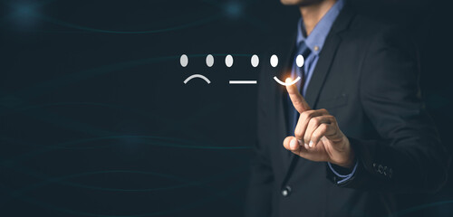 Customer Service and Satisfaction Concept Businessmen touch the virtual screen on happy smiley icons to achieve service satisfaction and feedback with excellent rated reviews.