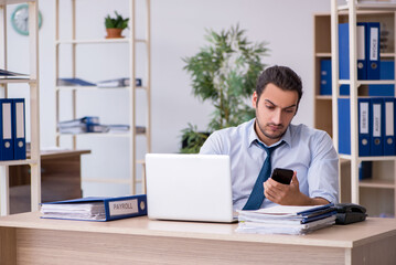 Fototapeta premium Young male bookkeeper working in the office