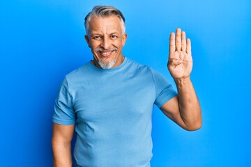 Middle age grey-haired man wearing casual clothes showing and pointing up with fingers number four while smiling confident and happy.