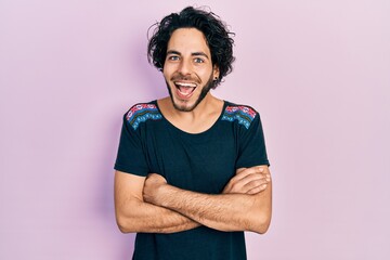 Obraz premium Handsome hispanic man with arms crossed gesture celebrating crazy and amazed for success with open eyes screaming excited.