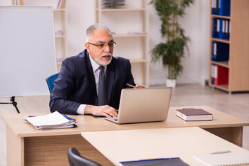 Old male employer in front of white board