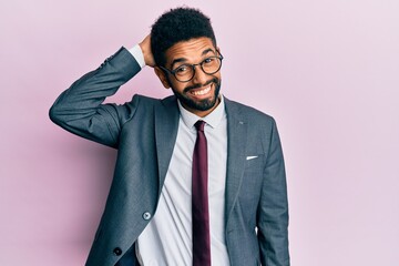 Handsome hispanic business man with beard wearing business suit and tie confuse and wonder about question. uncertain with doubt, thinking with hand on head. pensive concept.