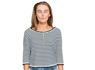 Fototapeta premium Beautiful blonde woman wearing casual clothes making fish face with lips, crazy and comical gesture. funny expression.