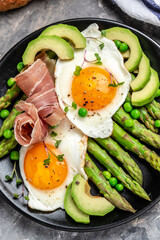 fresh organic asparagus with prosciutto, avocado and fried eggs. Healthy food, ketogenic diet, diet lunch concept. Keto Paleo diet menu, top view