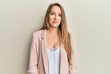 Obraz premium Young blonde woman wearing business jacket and glasses relaxed with serious expression on face. simple and natural looking at the camera.