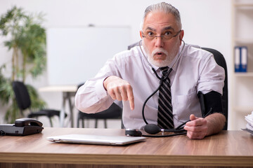 Aged male employee suffering at workplace