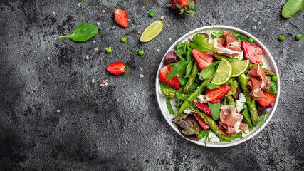 Healthy food. green asparagus, strawberry, rocket and cottage cheese salad. Diet banner, menu recipe place for text, top view