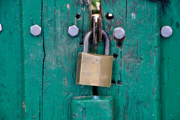 Metal padlock on wooden door. Close up details of metal padlock on wooden door. Old vintage lock on a wooden door.