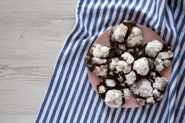Homemade Chocolate Crinkle Cookies on a pink plate, top view. Flat lay, overhead, from above.