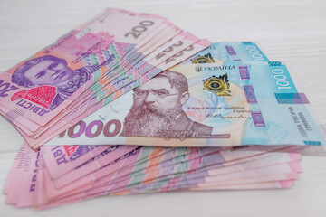  200 and 1000 hryvnia on a wooden background.