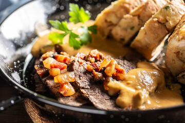 Typical Czech food svickova with beef slices, cream sauce and bread dumplings and fried bacon cubes