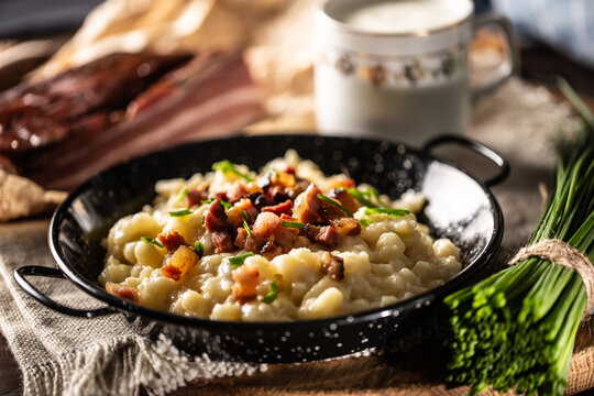 Halusky as traditional Slovak potato gnocchi with sheep cheese bryndza, fried bacon and chives