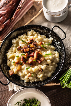 Top view of typical Slovakian food halusky with bryndza cheese, topped with bacon and chives