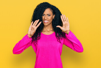 Middle age african american woman wearing casual clothes showing and pointing up with fingers...